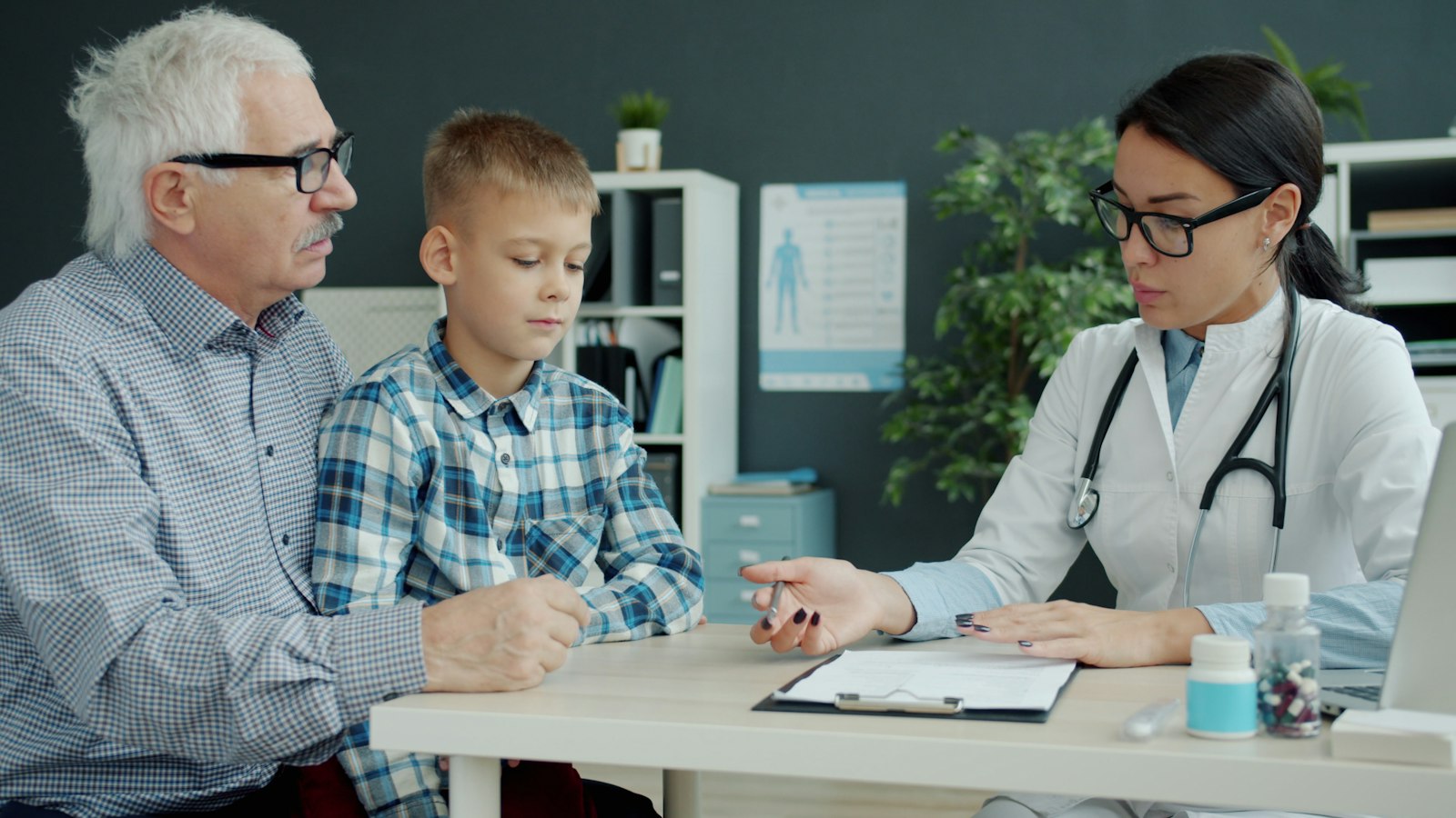 A primary care physician meeting with a boy and his grandfather