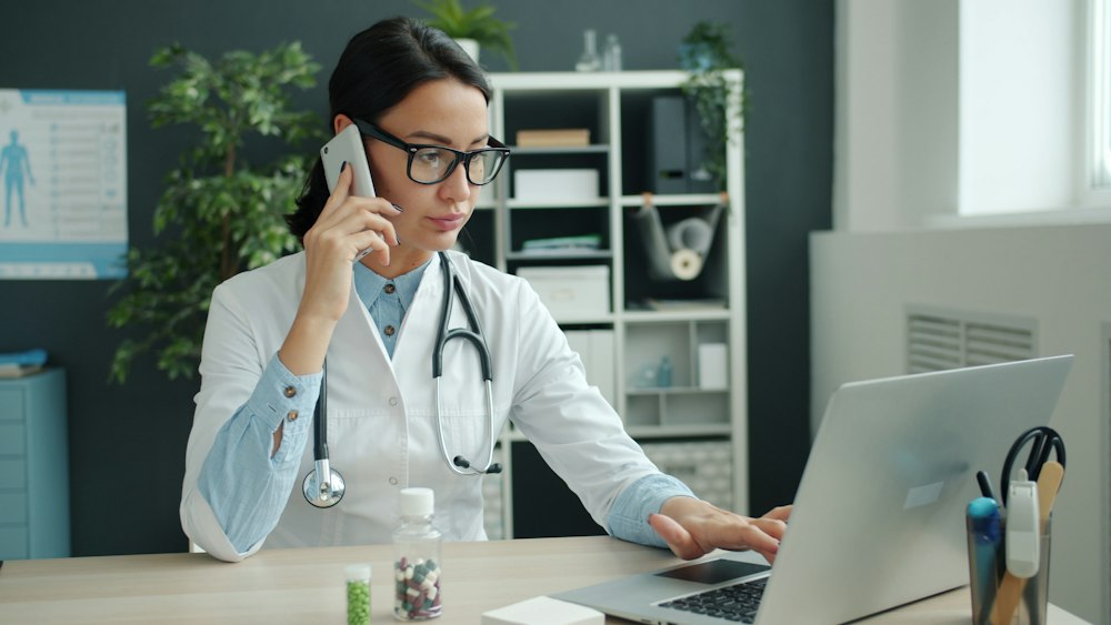 A clinician reviewing a patient case by phone